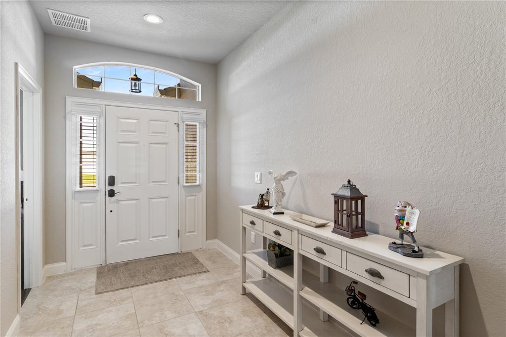 A tiled entryway leads through an arched doorway into a living and dining area — 117 WALKERS POINT DRIVE, AUBURNDALE, FL