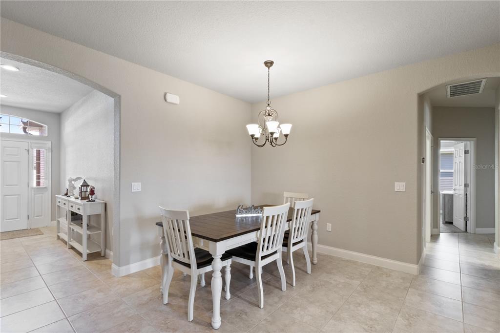 A living room features a white sofa, a wooden coffee table, and light-colored wood flooring — 117 WALKERS POINT DRIVE, AUBURNDALE, FL