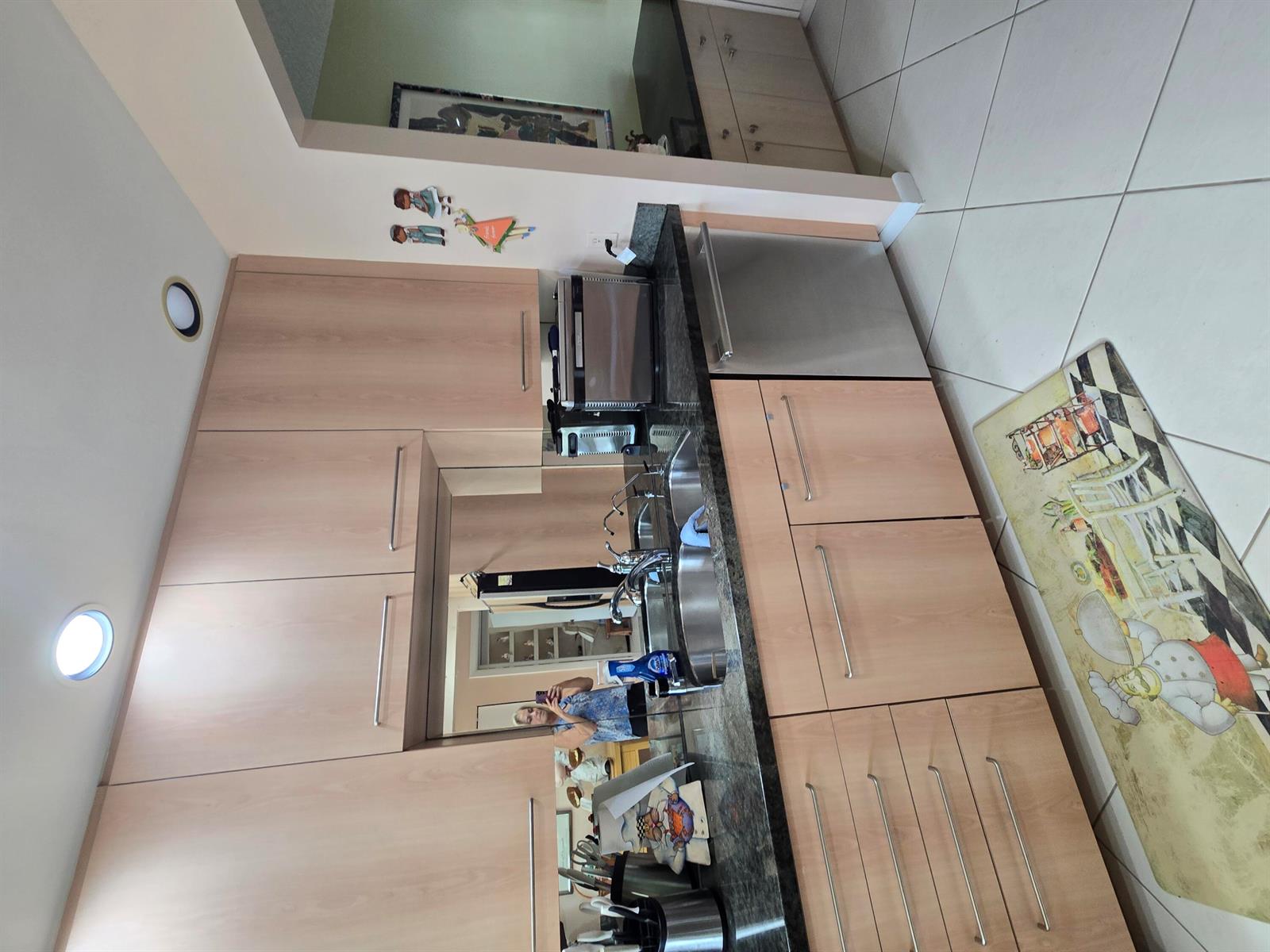 A kitchen features light wood cabinets, dark granite countertops, stainless steel appliances, and tile flooring — 21500 Cypress Hammock Drive # 38e, Boca Raton FL 33428, BOCA RATON, FL