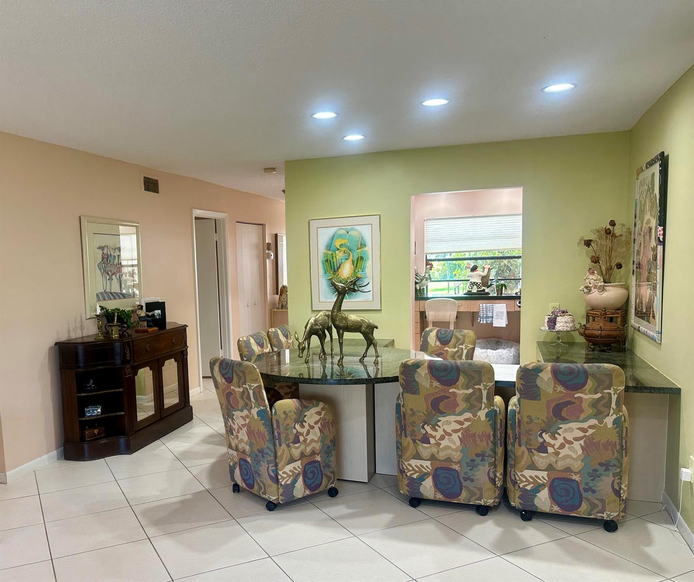 A dining area features a round green stone table, patterned chairs, and a wooden sideboard — 21500 Cypress Hammock Drive # 38e, Boca Raton FL 33428, BOCA RATON, FL