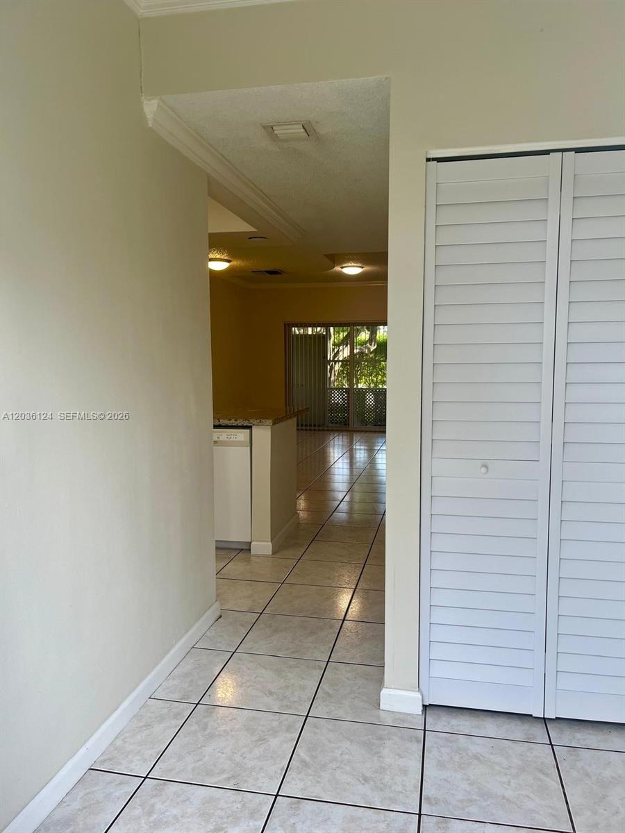 A tiled hallway leads toward a kitchen and a sliding glass door to a patio — WESTON, FL