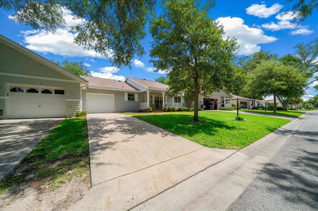 A single-story house with two garages, a concrete driveway, and a front lawn — 8715 SW 97TH STREET UNIT E, OCALA, FL