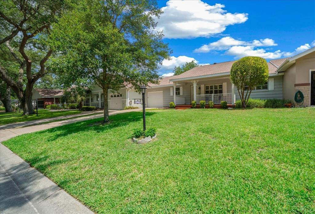 A single-story house with a gray exterior, a front porch, and a large grassy lawn — 8715 SW 97TH STREET UNIT E, OCALA, FL