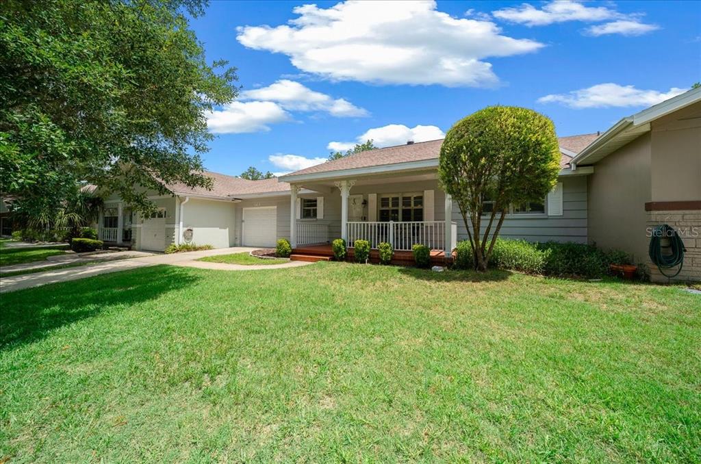 A single-story house with a covered front porch, white railings, and a green lawn — 8715 SW 97TH STREET UNIT E, OCALA, FL