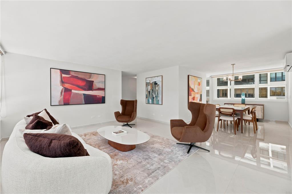 A modern living and dining area with white tile floors, brown armchairs, and abstract art — 1503 ASHFORD AVENUE UNIT 3C, SAN JUAN, PR