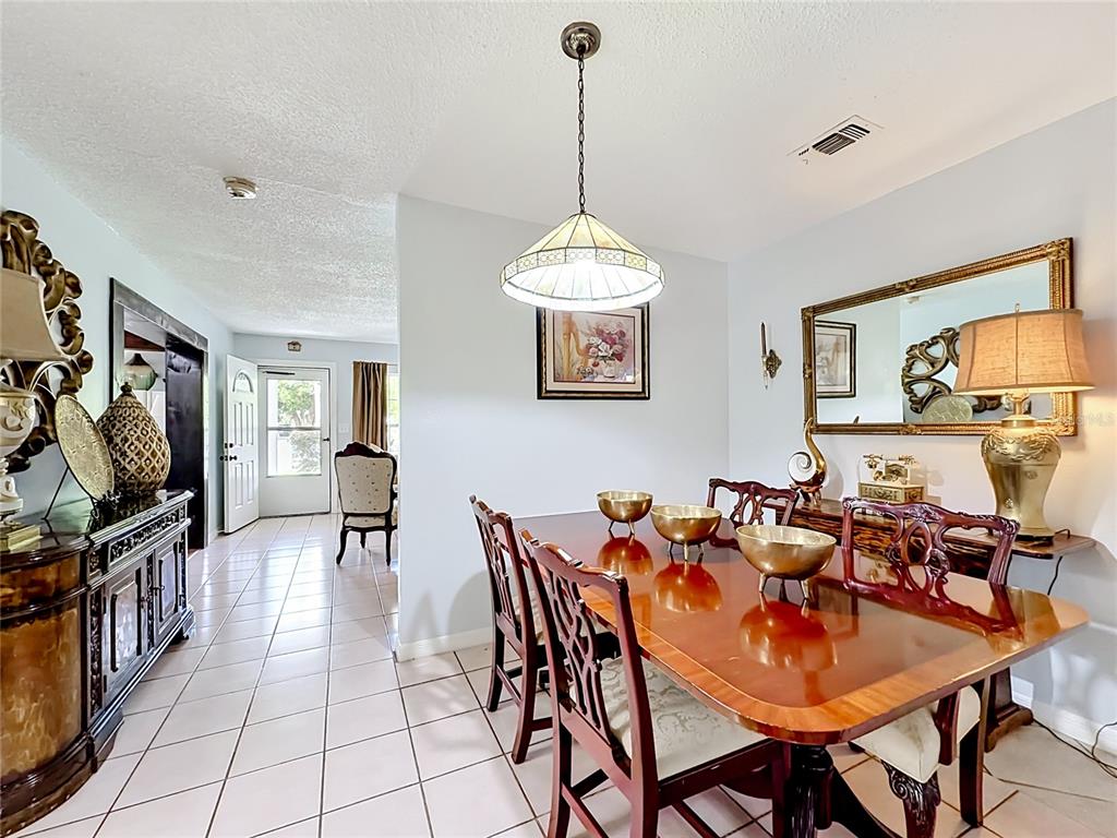 A living room features a white brick fireplace, tile flooring, and neutral-toned furniture — 2705 ARC DRIVE, ORLANDO, FL