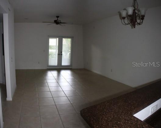 An open living area with tile flooring, a ceiling fan, and glass doors to the outside — 2935 NE 7TH STREET UNIT 207, OCALA, FL