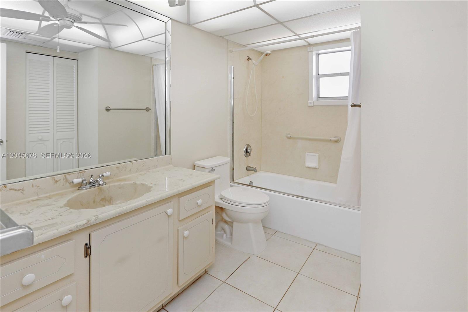 A bathroom features a vanity with a marble countertop, a toilet, and a shower-tub combo — 505 E Dania Beach Blvd # 3G, Dania Beach FL 33004, DANIA BEACH, FL