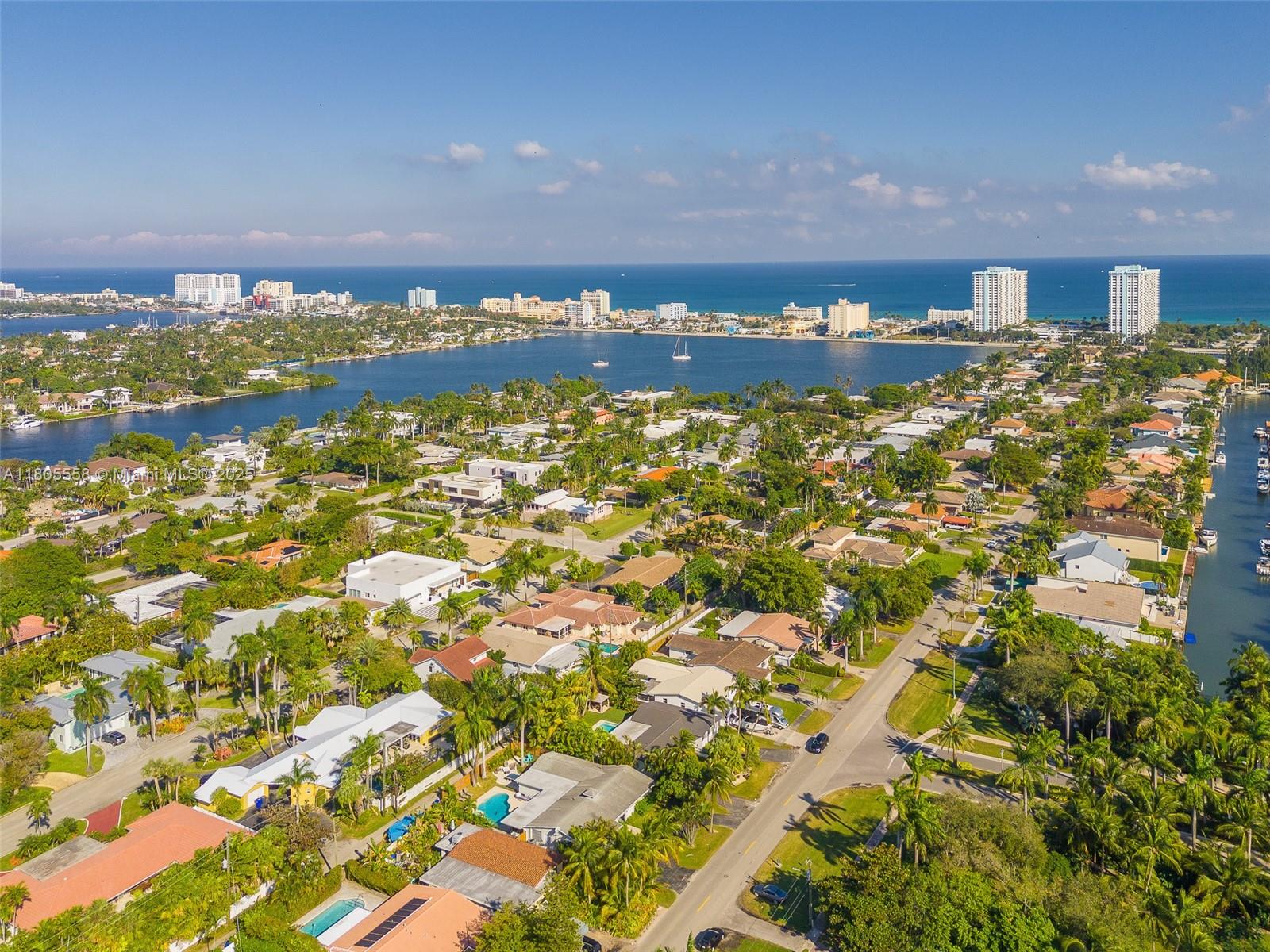 A backyard features a rectangular swimming pool, lounge chairs, a gazebo, and lush tropical landscaping — 1025 Washington St, Hollywood FL 33019, HOLLYWOOD, FL