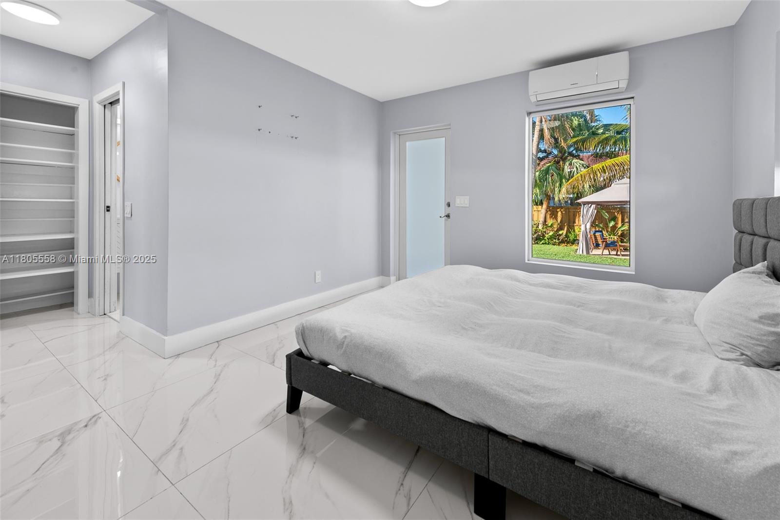 A living room with a white sectional, marble floors, wood-beamed ceiling, and floor-to-ceiling windows — 1025 Washington St, Hollywood FL 33019, HOLLYWOOD, FL