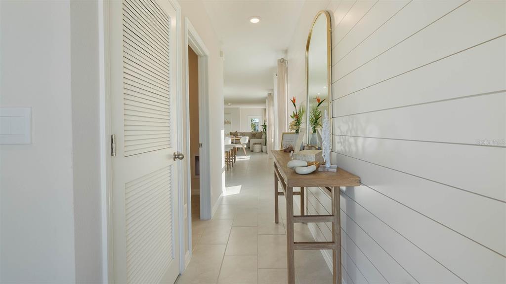 A hallway features white shiplap walls, a wooden console table, and a louvered closet door — 4417 LAKE FOX DRIVE, LAKELAND, FL