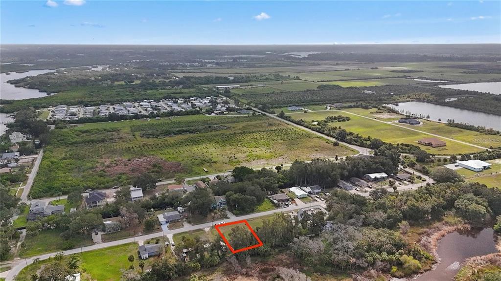 An aerial view shows a vacant, rectangular lot outlined in red along a rural road — 1115 CANAL STREET, RUSKIN, FL