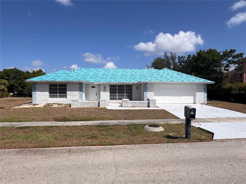 A single-story house with a white brick exterior and a blue underlayment roof — 4419 CREWS COURT, PORT CHARLOTTE, FL