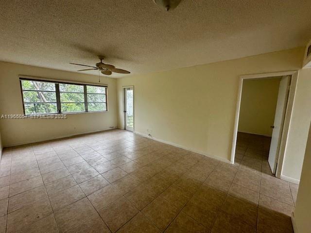 An empty room features beige tile flooring, a ceiling fan, and a glass door — 2223 Park Ln # 304, Hollywood FL 33021, HOLLYWOOD, FL