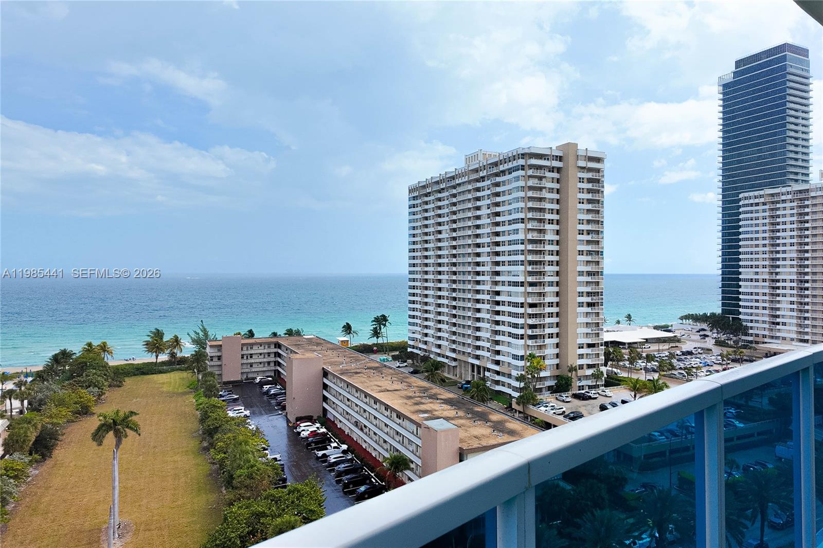 An elevated view shows a coastal landscape with high-rise buildings, a parking lot, and ocean — 1945 S Ocean Dr # 1114, Hallandale Beach FL 33009, HALLANDALE BEACH, FL