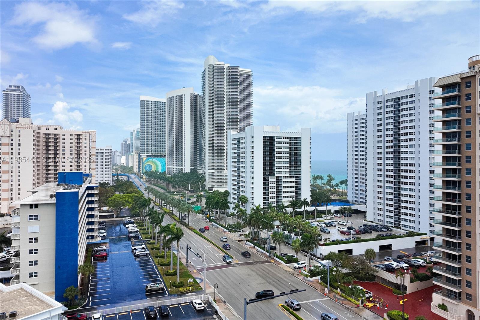 An elevated view shows a multi-lane road lined with tall residential buildings and palm trees — 1945 S Ocean Dr # 1114, Hallandale Beach FL 33009, HALLANDALE BEACH, FL
