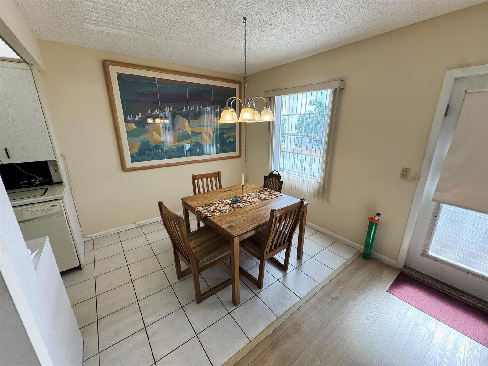 A dining area features a wooden table, four chairs, a pendant light, and tiled flooring — 4075 Cornwall D, Boca Raton FL 33434, BOCA RATON, FL
