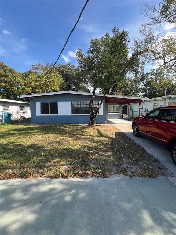 A single-story house with a blue facade, a carport, and a red car parked outside — 1505 S WESTMORELAND DRIVE, ORLANDO, FL
