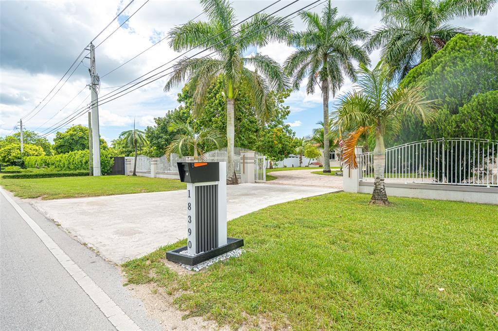 A modern mailbox with the house number 18390 stands in front of a gated driveway — 18390 SW 200TH STREET, MIAMI, FL