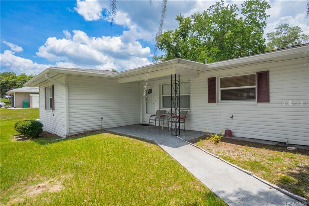 A white, single-story house with a covered front porch and a concrete walkway — 519 POPLAR STREET, INVERNESS, FL
