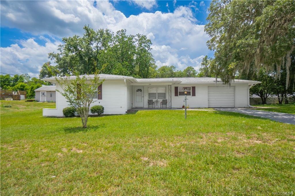 A single-story white house with a garage and a large front lawn — 519 POPLAR STREET, INVERNESS, FL