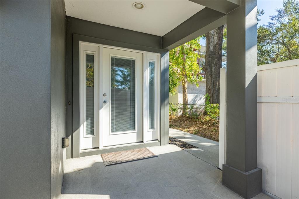 A covered concrete porch features a white front door with sidelights and gray trim — 113 S NEWPORT AVENUE UNIT 1-4, TAMPA, FL