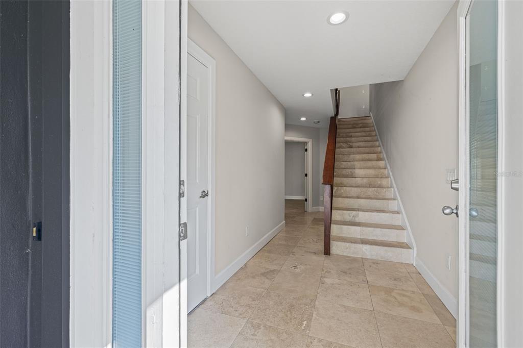 A tiled entryway features a staircase with a wooden handrail and a white door — 113 S NEWPORT AVENUE UNIT 1-4, TAMPA, FL