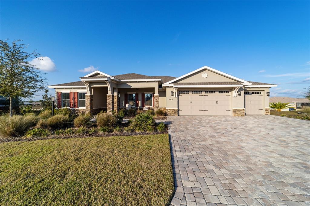 A concrete patio overlooks a fenced backyard with artificial turf and a distant neighborhood view — 10453 SW 99TH LANE, OCALA, FL