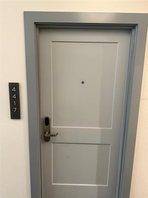 A gray door with a digital lock and a vertical sign labeled 4417 — 15695 GROVE RESORT AVENUE UNIT 4417, WINTER GARDEN, FL