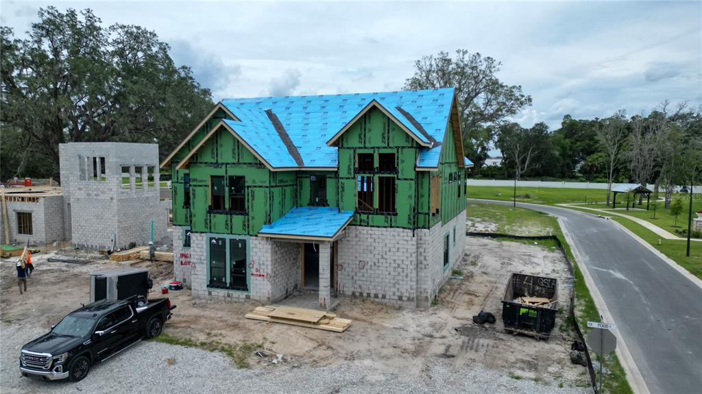 An aerial view shows a two-story house under construction with green sheathing and blue roof underlayment — 1146 PRADO LANE, OAKLAND, FL
