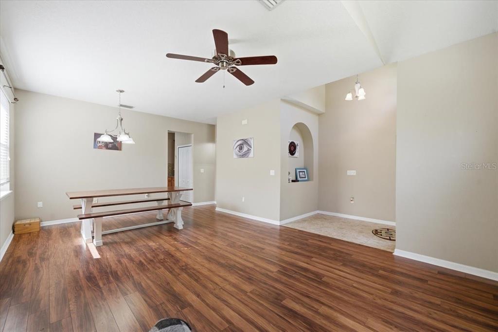 A dining area with wood-look flooring, a ceiling fan, and a built-in wall niche — 11844 COLONY LAKES BOULEVARD, NEW PORT RICHEY, FL