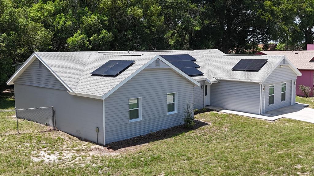 An exterior view of a gray, single-story house with solar panels on the roof — 6120 CENTENNIAL DRIVE, ORLANDO, FL