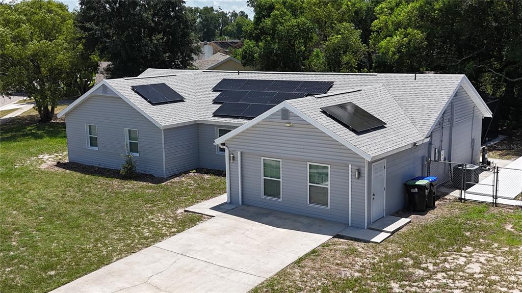 An aerial view of a gray, single-story house with solar panels on the roof — 6120 CENTENNIAL DRIVE, ORLANDO, FL
