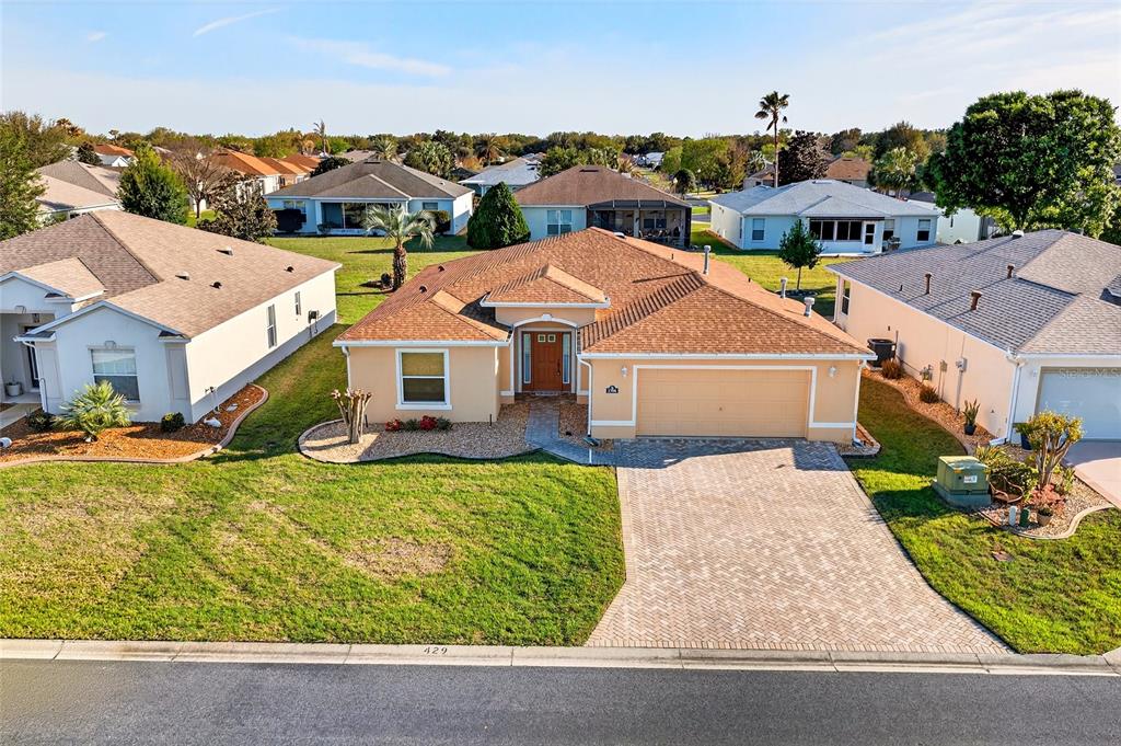 An aerial view of a single-story suburban house with a tan exterior and paved driveway — 1706 SW 156TH LANE, OCALA, FL