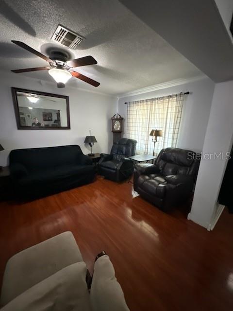 A living room features a dark sofa, two recliners, a grandfather clock, and hardwood floors — 4325 CAROLYN WAY, BARTOW, FL