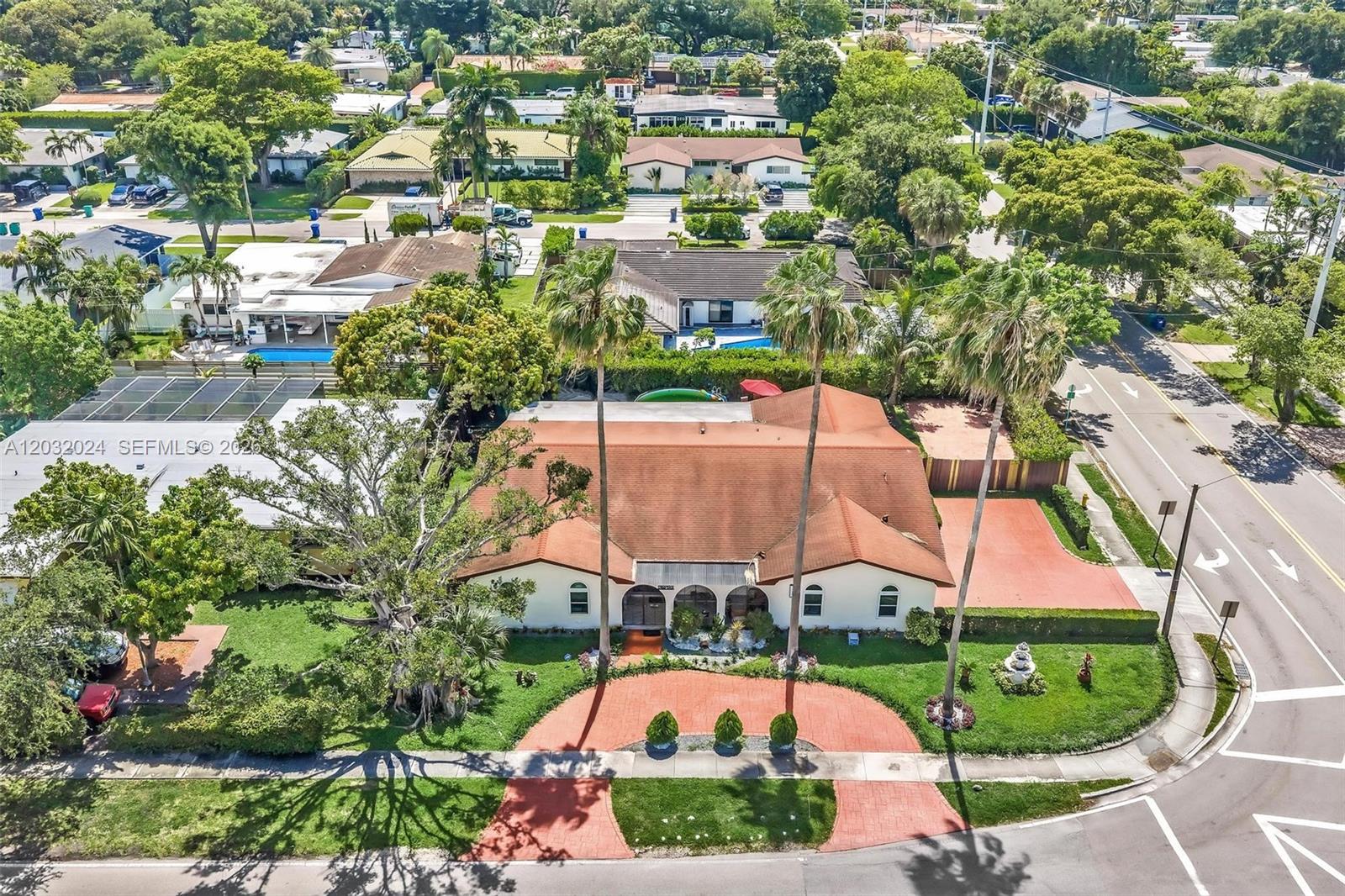 An aerial view shows a single-story house with a red roof, palm trees, and driveway — 19901 Highland Lakes Blvd, Miami FL 33179, MIAMI, FL