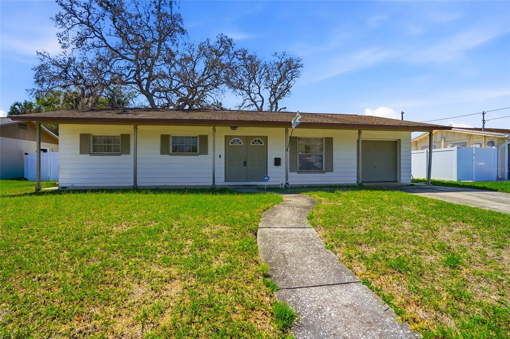 A single-story white house with a covered front porch and a concrete walkway — 3312 W BURKE ST, TAMPA, FL