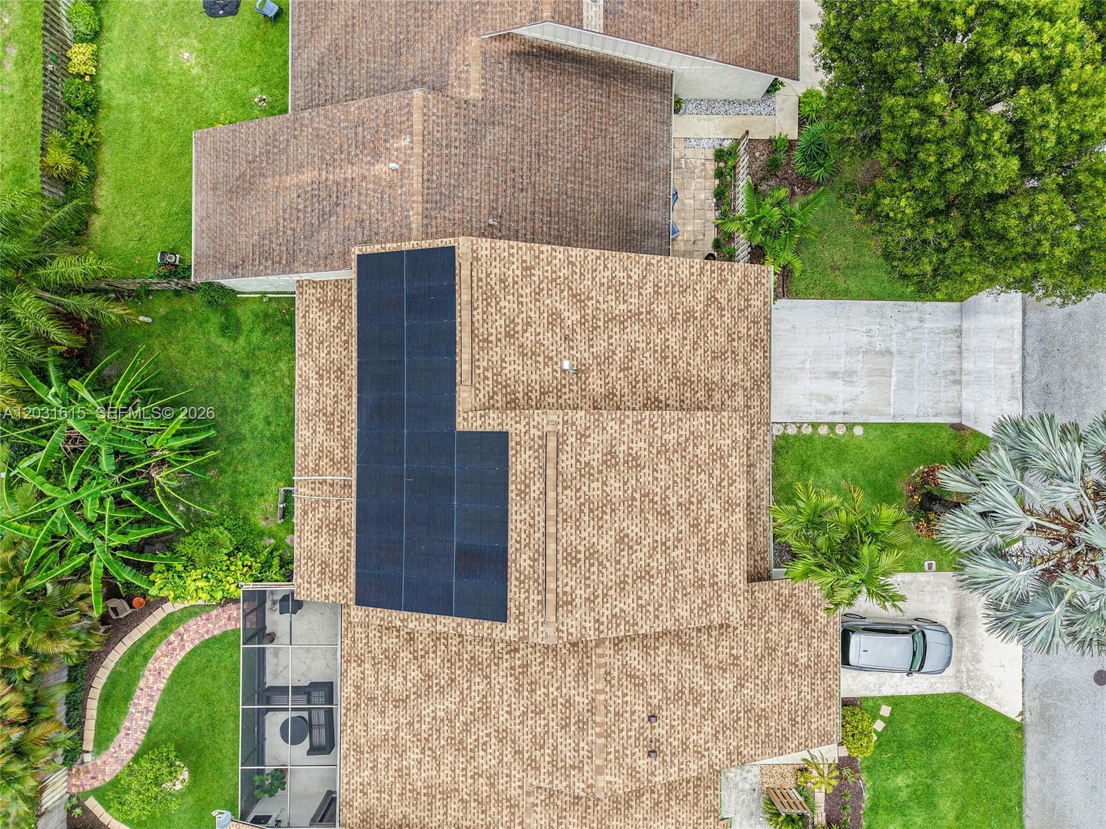 An aerial view shows a house with a shingled roof and solar panels — 11870 Donlin Dr, Wellington FL 33414, WELLINGTON, FL