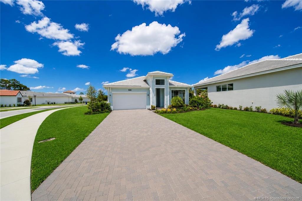A light blue single-story house with a paved driveway and a green lawn — 6941 SE Haven Lane, Stuart FL 34997, STUART, FL