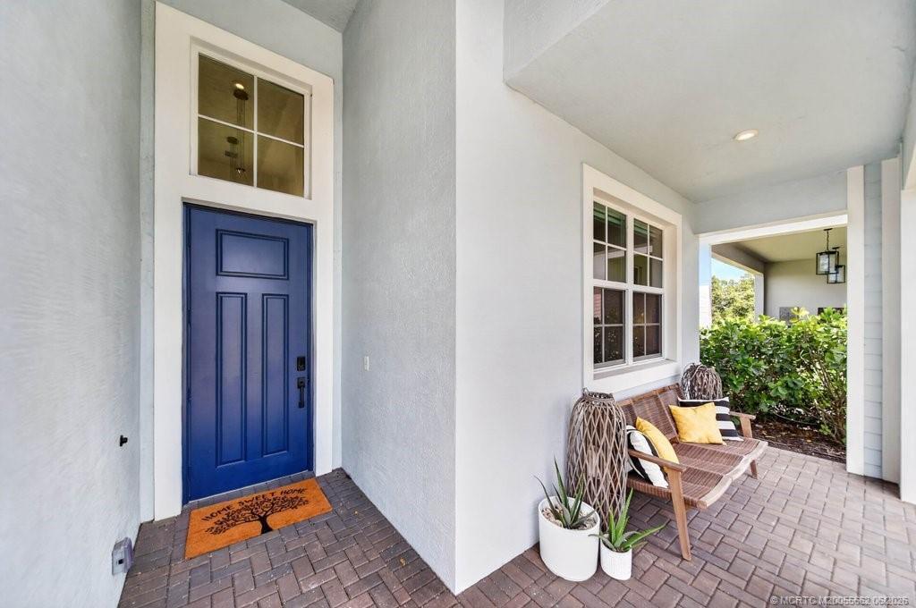 A modern white kitchen features a large marble island, stainless steel appliances, and three pendant lights — 6941 SE Haven Lane, Stuart FL 34997, STUART, FL