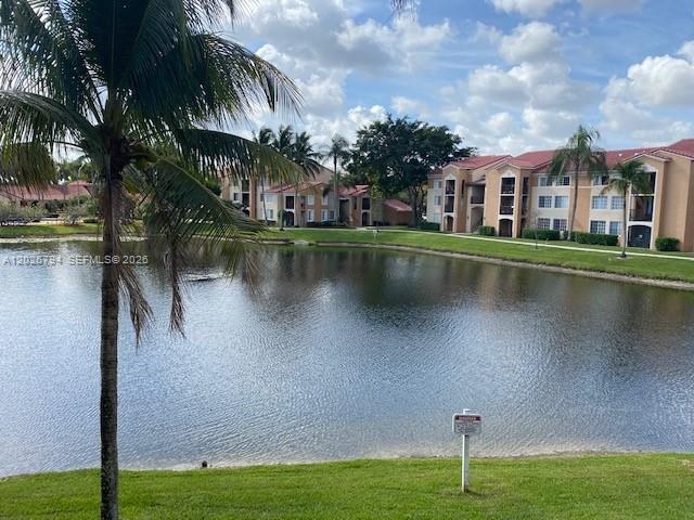 A palm tree overlooks a lake in front of a multi-story apartment complex — 2051 Renaissance Blvd # 206, Miramar FL 33025, MIRAMAR, FL