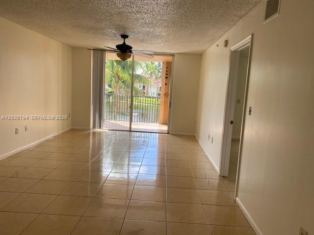 An empty room with beige tile floors, a ceiling fan, and a sliding glass door — 2051 Renaissance Blvd # 206, Miramar FL 33025, MIRAMAR, FL