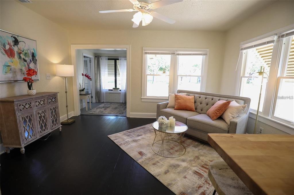 A living room features dark wood floors, a tufted sofa, and a ceiling fan — 2521 4TH STREET S, ST PETERSBURG, FL