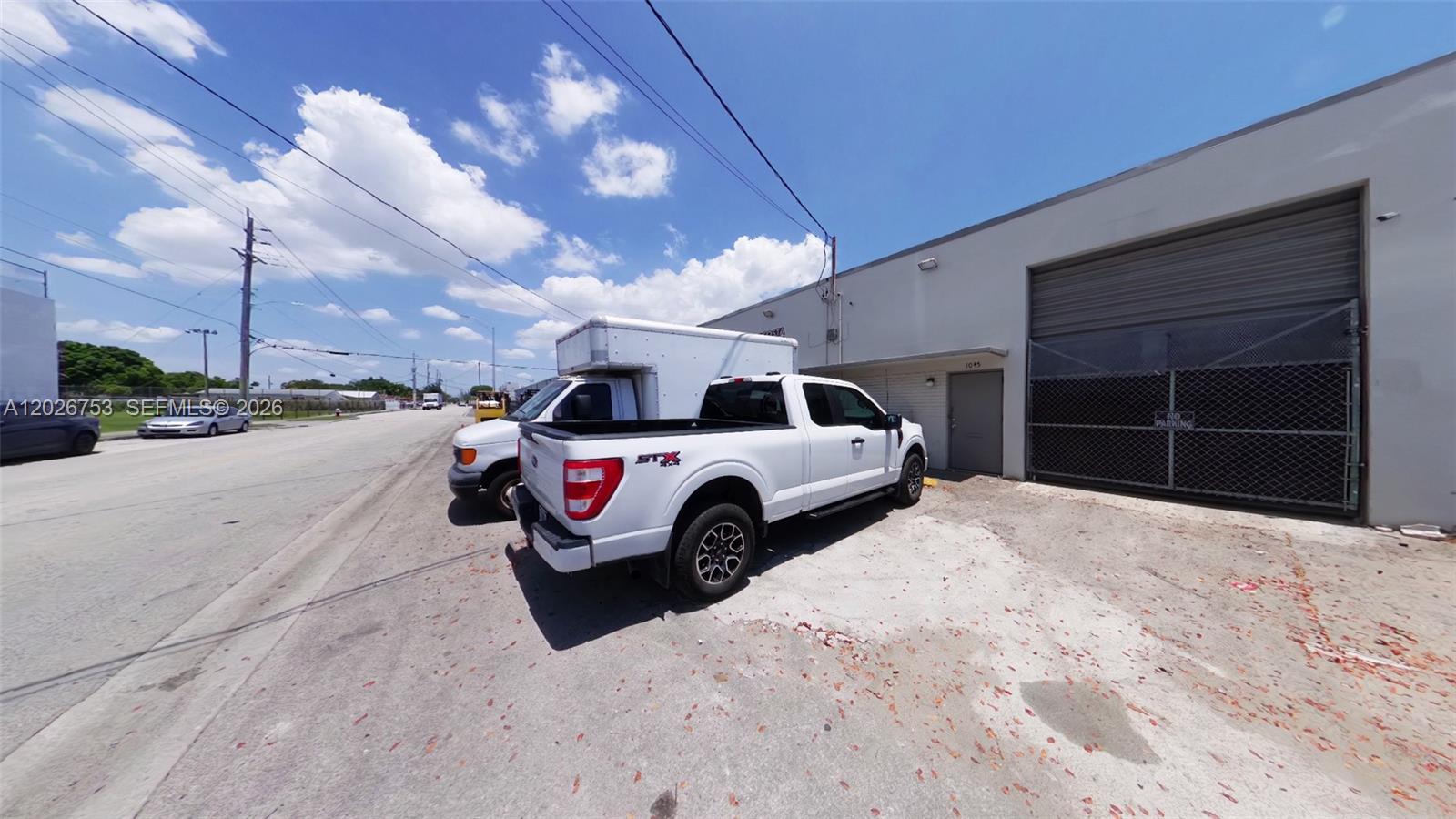 A white pickup truck is parked in front of a commercial building with a roll-up door — 1055 SE 9th Ct # 65, Hialeah FL 33010, HIALEAH, FL