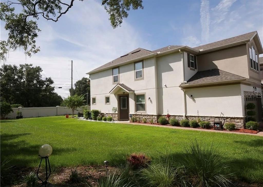 A two-story house with a stucco exterior, stone accents, and a large green lawn — 3778 BRIGHTON PARK CIRCLE, ORLANDO, FL