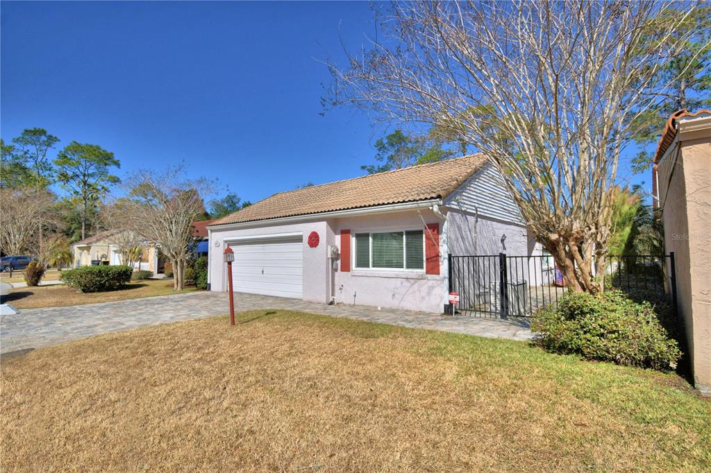 A single-story house with a white garage, light pink stucco walls, and a tiled roof — 447 SAN JOSE DRIVE, WINTER HAVEN, FL