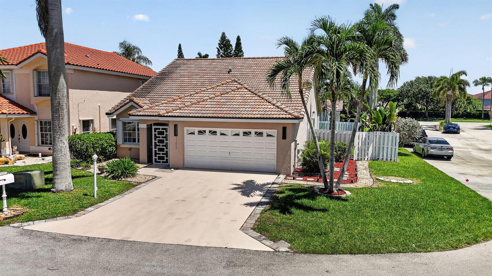 A single-story house with a tan stucco exterior, a tiled roof, and a two-car garage — 11213 Jasmine Hill Circle, Boca Raton FL 33498, BOCA RATON, FL