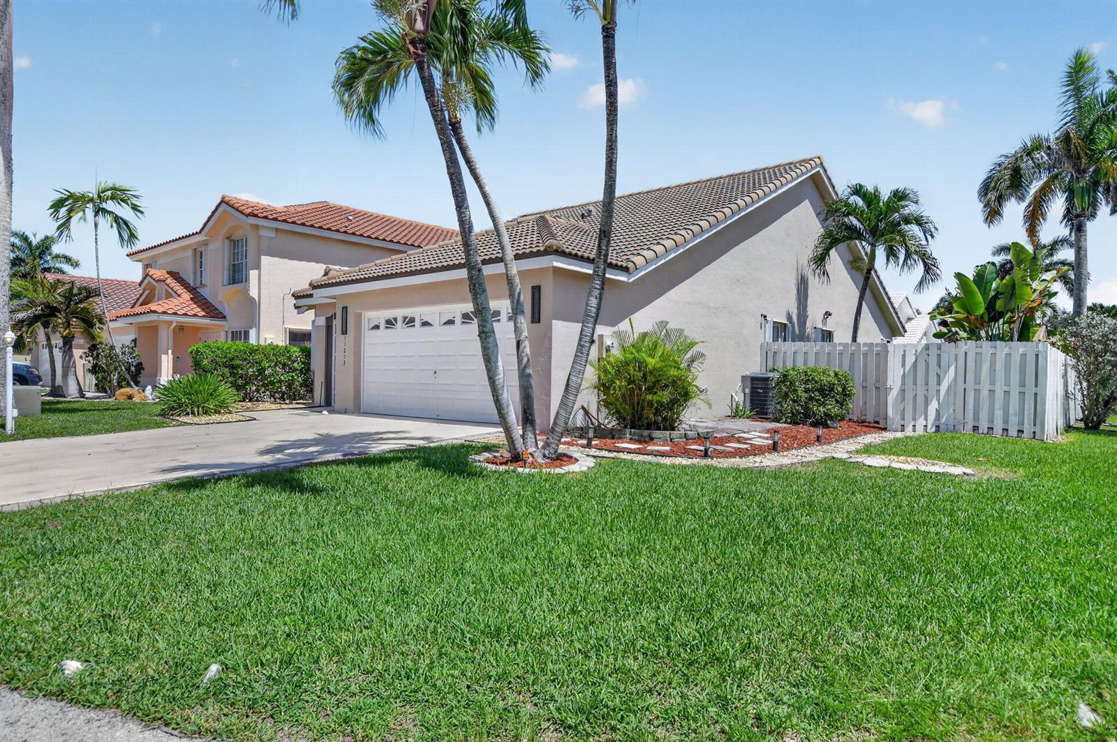 A single-story house with a white garage door, palm trees, and a white fence — 11213 Jasmine Hill Circle, Boca Raton FL 33498, BOCA RATON, FL