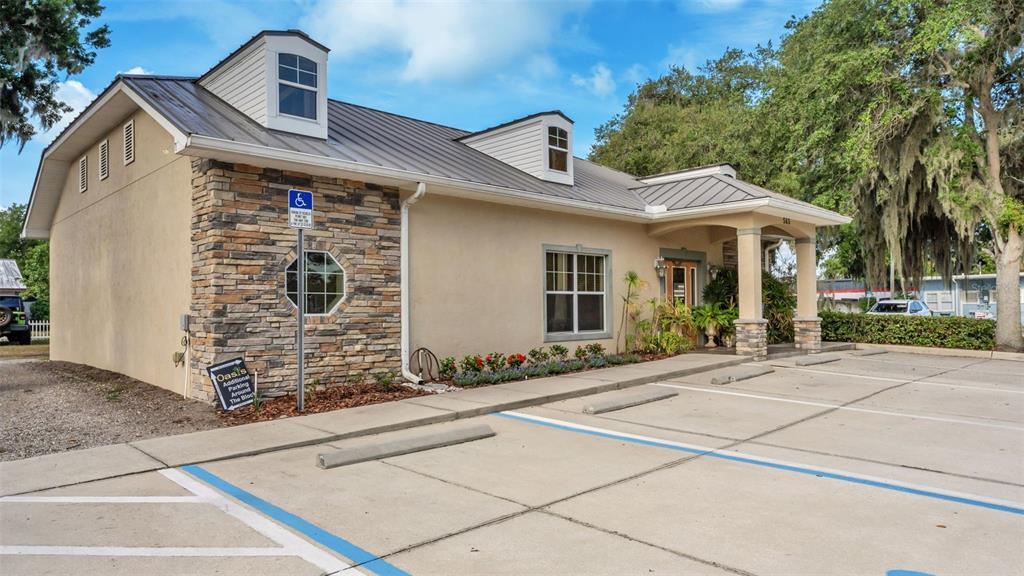 A single-story commercial building with a metal roof, stone facade, and a paved parking lot — 565 W MAIN STREET, BARTOW, FL