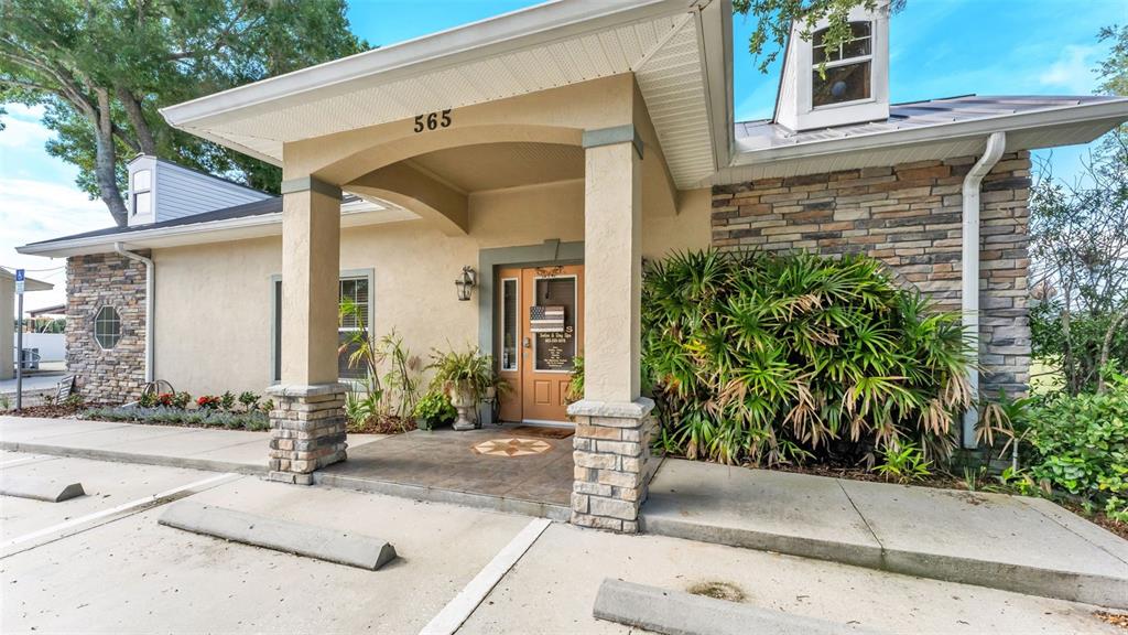 The exterior of a building features a covered entrance with stone pillars and a door — 565 W MAIN STREET, BARTOW, FL